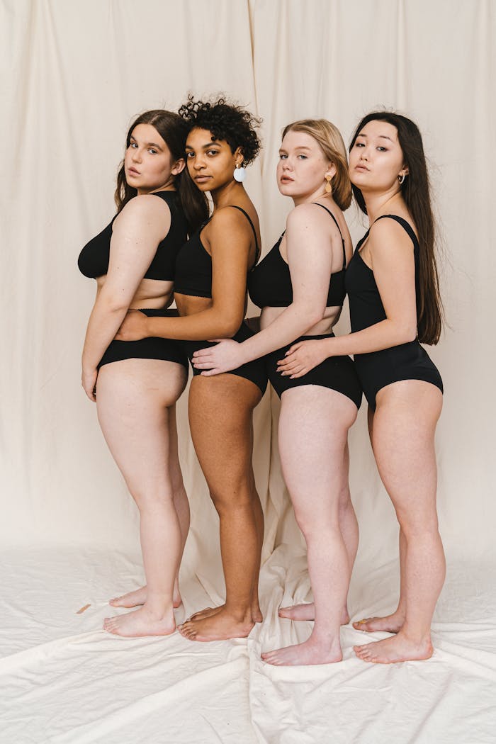 Home A diverse group of women standing in black underwear against a neutral backdrop.